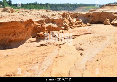Background of yellow sand with small stones after rain. Soil erosion after heavy rainfall and precipitation. Texture of scattered sand fine gravel Stock Photo
