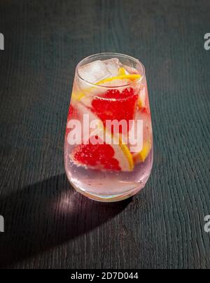 pink grapefruit drink with ice on black wooden table Stock Photo