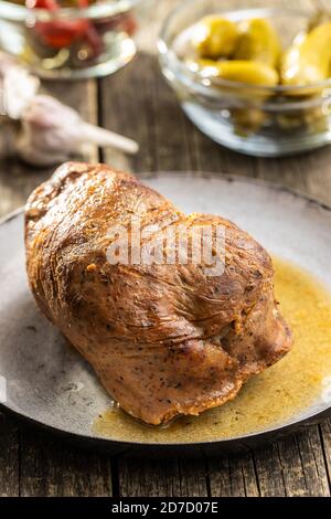 Roasted pork meat on pan on wooden table. Stock Photo