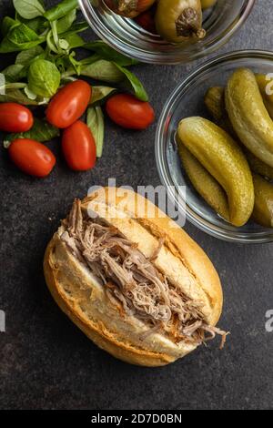 Sandwich with pulled meat on black table. Top view. Stock Photo