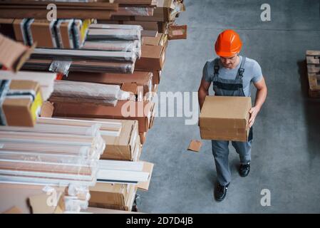 Top view of male worker in warehouse with box in hands Stock Photo