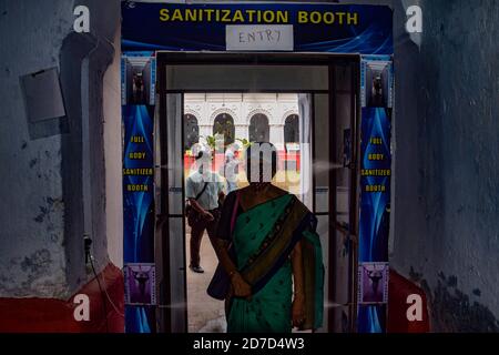 A devotee entering through a sanitization booth at the puja pandal in Kolkata.Durga puja is one of the most popular festivals celebrated in West Bengal and particularly in Kolkata, but Kolkata High court declared Puja pandals as 'no entry zones' and 'containment zone' for all the visitors amid the covid19 pandemic. Stock Photo