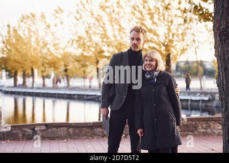 Grandmother with young guy in formal clothes in an autumn park Stock Photo