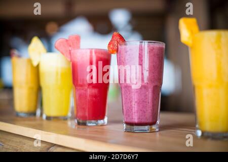 A selection of Fruit shakes displayed together in formation on a table bar Stock Photo