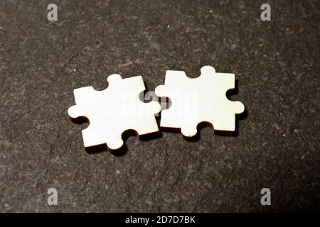 Two pieces of white puzzle and fitting them together concept for solution or partnership Stock Photo