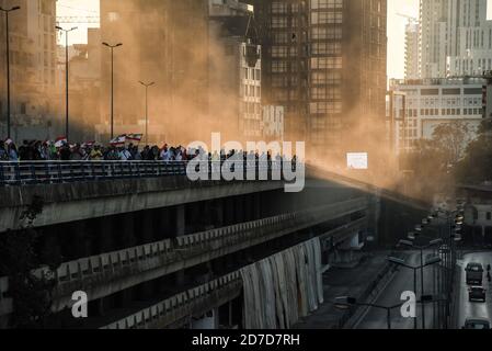 Beirut, Lebanon, 17 October 2020. Sunbeams light up a cloud of dust drifting on the breeze from the site of the 4 August Beirut blast as anti-government protesters march from Downtown Beirut to a highway opposite the blast site to mark the anniversary of the Lebanese Thawra, one year after protests began on 17 October 2019 Stock Photo