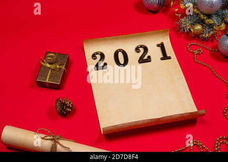 Parchment paper and a scroll for the to-do list and text for the new year 2021 on a red background. Christmas, holiday card with plans for next year Stock Photo