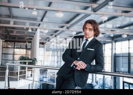 Portrait of handsome young businessman in black suit and tie Stock Photo