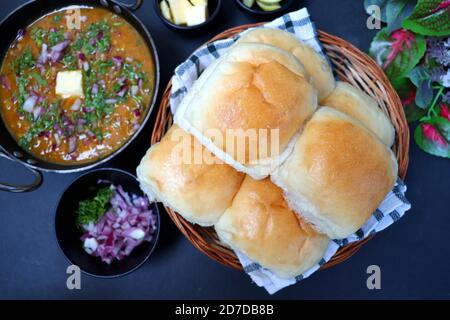 Indian Mumbai Street style Pav Bhaji, garnished with peas, raw onions, coriander & Butter. Spicy thick curry made of out mixed vegetables. copy space. Stock Photo