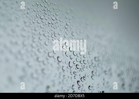 multiple rain drops on a grey window during a thunder storm Stock Photo