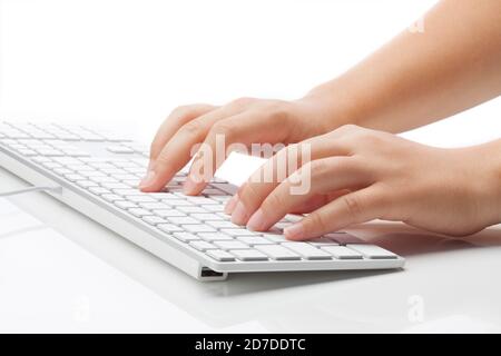Young woman typing on keyboard. Smooth light against white background Stock Photo
