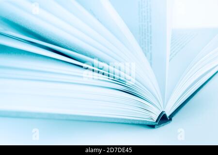 Shallow depth of field in open book in blue color. Defocused pages works like copy space Stock Photo