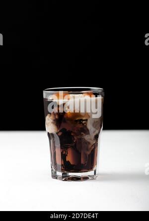 https://l450v.alamy.com/450v/2d7de4t/glass-of-black-coffee-with-ice-cubes-and-fresh-milk-on-white-board-and-black-background-2d7de4t.jpg