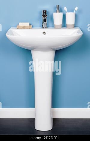 https://l450v.alamy.com/450v/2d7dff1/vertical-shot-of-a-white-modern-pedestal-bathroom-sink-with-soap-and-toothbrushes-2d7dff1.jpg