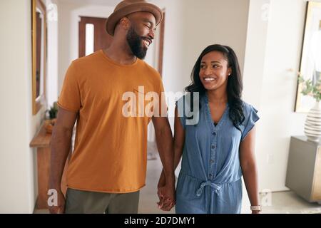 Loving African American Couple Walking Into Hall At Home Holding Hands Stock Photo
