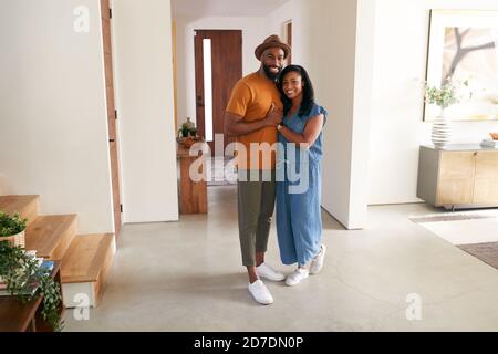 Portrait Of Loving African American Couple Hugging In Hall At Home Stock Photo