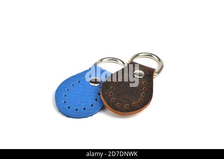Blank blue brown round color leather key chain collection on isolated white background with clipping path. Pile set of metallic souvenir. Stock Photo