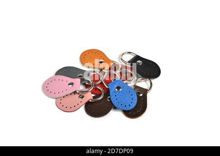 Blank round color leather key chain collection on isolated white background with clipping path. Pile set of metallic souvenir. Stock Photo