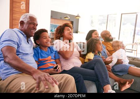 Multi-Generation African American Family Relaxing At Home Sitting On Sofa Watching TV Together Stock Photo