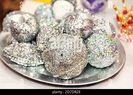 Christmas tree decorations - balls with silver glitter on a tray at the fair. Stock Photo