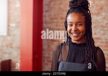 Portrait Of Smiling Female Coffee Shop Owner Wearing Apron Stock Photo