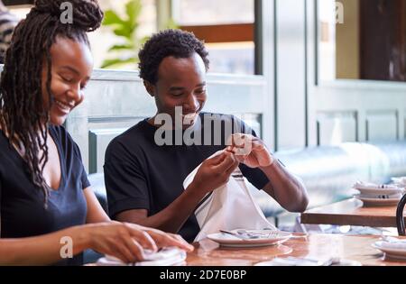 Male And Female Waiters Folding Napkins In Restaurant Before Service Stock Photo