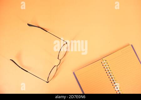 high angle view of open notepad on orange background  Stock Photo
