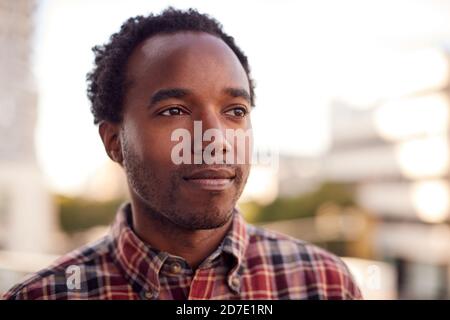 Portrait Of Thoughtful Businessman Standing Outside Office Building With City Skyline In Background Stock Photo