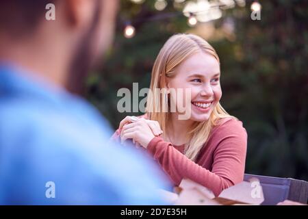 Woman In Garden At Home With Friends Enjoying Summer Garden Party Stock Photo