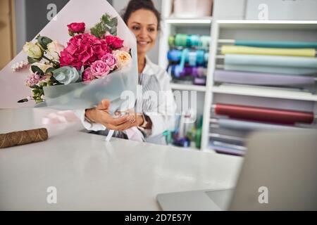 Professional flower shop assistant holding a beautiful bouquet Stock Photo