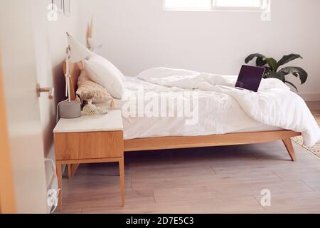 Interior View Of Beautiful Bedroom With Laptop On Duvet In New Family House Stock Photo