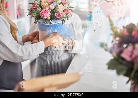 Two professional flower shop workers getting a bouquet ready