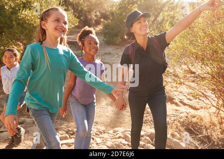 Adult Team Leaders With Group Of Children At Outdoor Activity Camp Walking Through Countryside Stock Photo