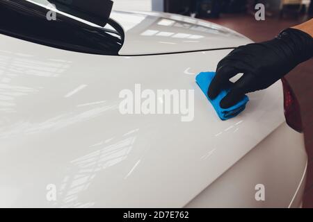 Car detailing - Man applies nano protective coating to the car. Selective focus. Stock Photo