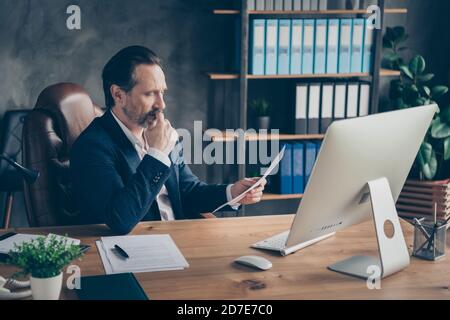 Profile side view portrait of his he nice handsome focused busy man qualified specialist reading project start-up documentation at modern concrete Stock Photo