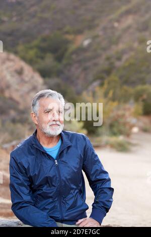 Outdoor Portrait Of Serious Hispanic Senior Man With Mental Health Concerns Stock Photo