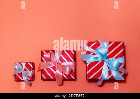 Creative Christmas Composition with Three Gift Boxes on Red Background. Top View Flat Lay. Stock Photo
