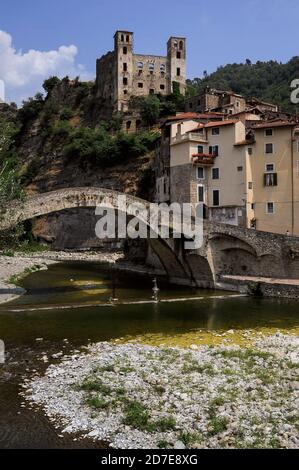 Ponte Vecchio, a 1400s bridge over the River Nervia at Dolceacqua, Liguria, Italy, with the medieval Doria Castle, its square Renaissance towers added in the 1500s, rising above the Terra, the old town. French Impressionist artist Claude Monet (1840 - 1926) called the Ponte Vecchio “un bijou de légèreté” (a jewel of lightness) on a visit to Dolceacqua in 1884 and painted four works featuring the bridge and the castle. Stock Photo