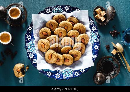 turkish cookies with almonds and coffee on the table in    traditional dishes: a plate with an ornament and copper cups. tea time Stock Photo