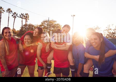 Portrait Of Womens Football Team Relaxing After Training For Soccer Match On Outdoor Pitch Stock Photo