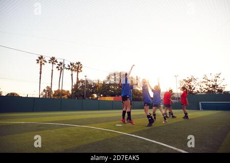 Womens Football Team Celebrating Scoring Goal In Soccer Match On Outdoor Astro Turf Pitch Stock Photo