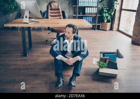 Above high angle view portrait of his he fired miserable man sales realtor executive specialist sitting on floor going home at modern loft brick Stock Photo