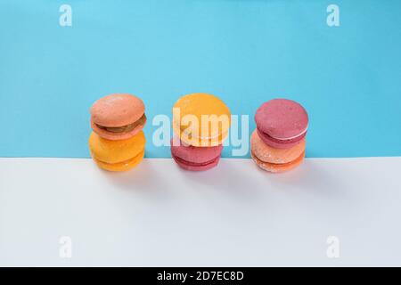 Macaroons lined up on two colored cardboards. Making a composition with symmetry with parallel, diagonal and horizontal lines. Stock Photo