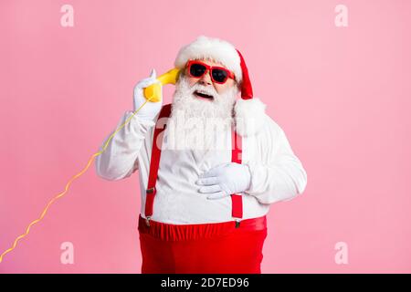 Portrait of his he nice attractive cheerful cheery glad Santa father talking on yellow phone contact center communication laughing good joke isolated Stock Photo