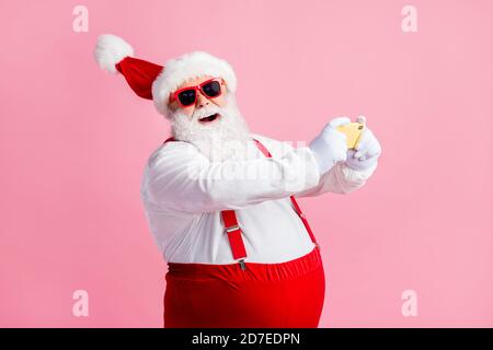 Profile side view portrait of his he cheerful bearded fat overweight Santa using cell browsing post social network blog 5g app fast speed having fun Stock Photo