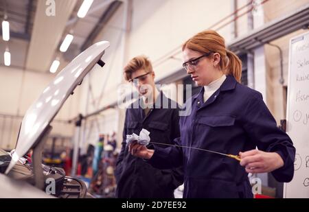 Male And Female Students Checking Car Oil Level On Auto Mechanic Apprenticeship Course At College Stock Photo