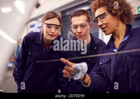 Female Tutor With Students Checking Oil Level In Car Engine On Auto Mechanic Course At College Stock Photo