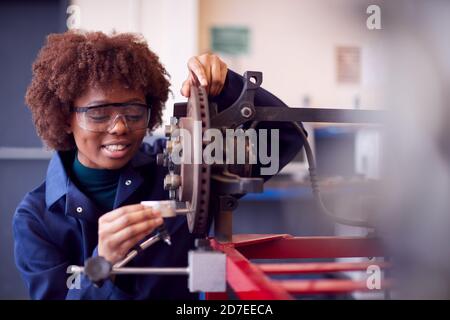 Female Student Working On Car Brakes On Auto Mechanic Apprenticeship Course At College Stock Photo