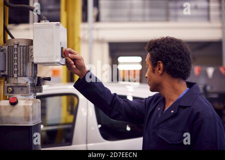 Male Motor Mechanic Raising Car On Hydraulic Lift In Garage Stock Photo