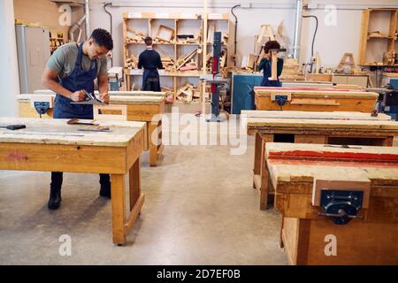Wide Angle View Of Carpentry Workshop With Students Studying For Apprenticeship At College Stock Photo